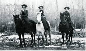 3 women sitting astride on horseback
